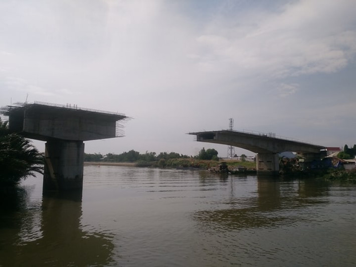 Tháng 6/2012, cầu mới chính thức được khởi công với gần 300 tỷ đồng và dự kiến xong sau 17 tháng. Nhưng đến nay, đã gần 10 năm trôi qua, cầu mới chỉ là hai khối nhịp dầm đúc hẫng nằm chơi vơi giữa rạch và bờ.