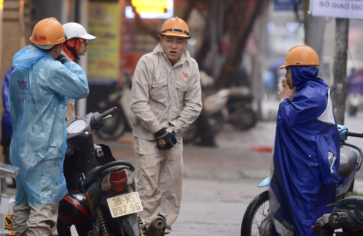 Một nam công nhân tỏ ra mặc chưa đủ ấm trước giờ bắt tay vào công việc tại một công trình gần đó.