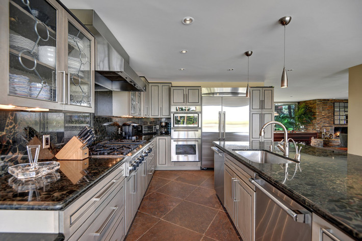 Nhà bếp hiện đại có quầy bar ăn sáng, mặt bếp bằng đá granite và các thiết bị bằng thép không gỉ.