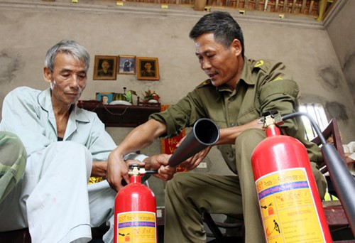Sau khi được báo cáo vụ việc, công an huyện Tam Nông đã cho người xuống điều tra và hỗ trợ gia đình 2 bình cứu hỏa. Bên cạnh đó, lực lượng công an xã Thượng Nông cũng thường xuyên cử người túc trực, theo dõi. Các cơ quan chức năng đã xuống nhà ông Hường khám nghiệm và lấy các mẫu phẩm, hiện vẫn chưa có kết luận cuối cùng. Trong ảnh: Công an viên xã Thượng Nông hướng dẫn ông Nguyễn Hồng Hường sử dụng bình cứu hỏa.