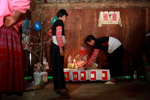 Đêm giao thừa, hầu hết người Mông không ngủ mà ngồi uống rượu thâu đêm chờ trời sáng. Khi tiếng gà gáy đầu tiên của sáng mồng 1 cất lên, người chủ gia đình sẽ đem 1 ít rượu, muối và xôi rắc trước cửa nhà thay cho lời mời Thổ công vào đón Tết cùng gia đình.