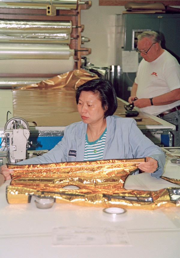 Các kỹ thuật viên Susan Ung và Andy Anderson đã cắt và khâu những tấm chăn nhiệt màu vàng cho phi thuyền Cassini của NASA. Nguồn ảnh: NASA.