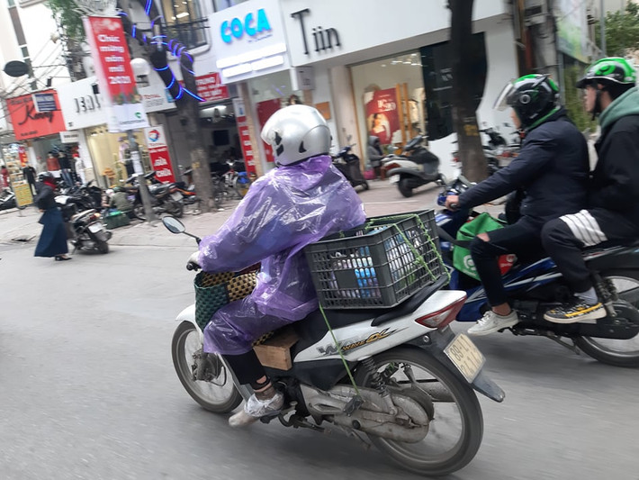 Do quá lạnh, nhiều người dân buộc phải mặc áo mưa để hạn chế sự khắc nghiệt của thời tiết