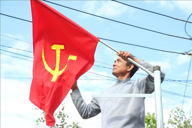 Người dân treo cờ trên tuyến đường chính của xã Cư Mgar.