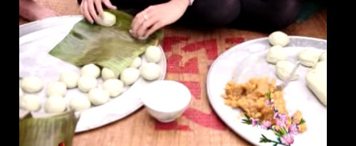 Lá chuối tươi nướng qua trên than hồng rồi đem gói bánh. Ảnh: youtube