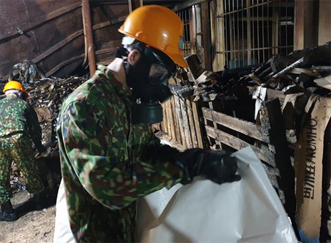 Qua đó, lực lượng tiêu độc được trang bị bảo hộ, mặt nạ chống độc đang tiến hành thu dọn.