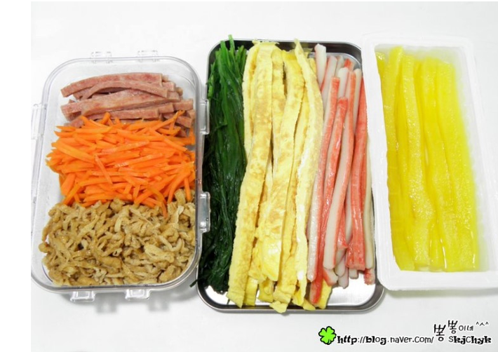 Nguyên liệu cần chuẩn bị: Lá hẹ: 100 gram; Gạo dẻo: 200 gam; Lá rong biển: 1 gói khoảng 4 lá; Thịt nguội; Thanh thịt tôm: 5 cái; Cà rốt: 2 củ; Dưa chuột: 2 quả; Củ cải vàng muối Hàn Quốc; Trứng gà : 3 quả; Dụng cụ để cuốn như: Mành tre; Dầu vừng; Giấm; Muối; Sốt mayonnaise