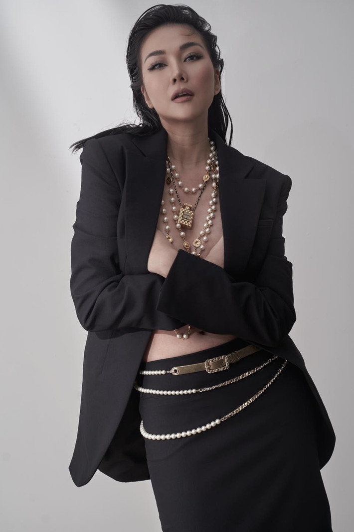 Thanh Hằng dùng tay ôm ngực trần khi diện set đồ áo blazer không nội y kết hợp chân váy ôm. Ảnh: Trịnh Duy Linh.
