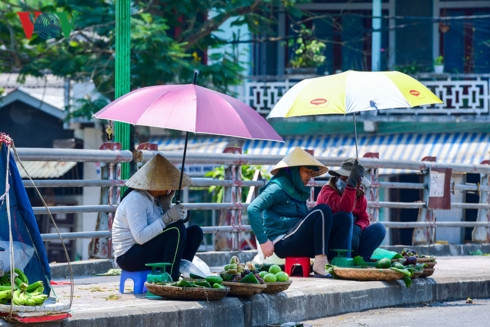 Những người bán hàng rong trang bị dù và nón để chống lại cái nóng từ vỉa hè hắt lên.