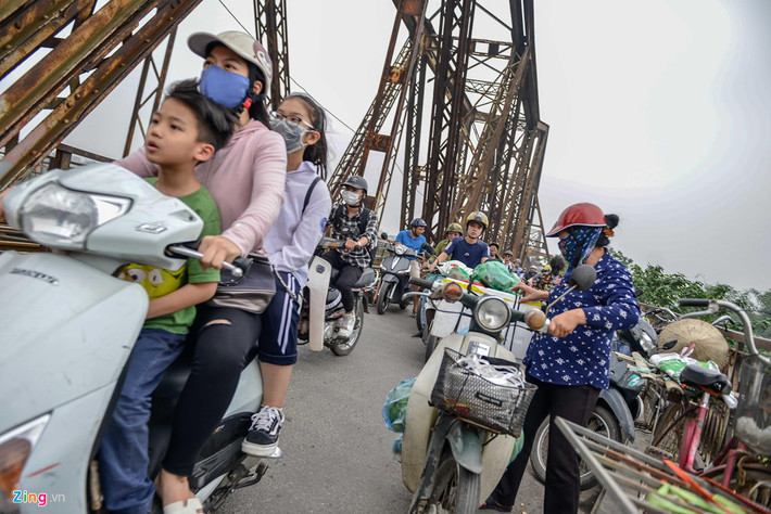 Dọc hai bên cầu có đến hơn chục điểm người dân họp chợ. Thỉnh thoảng những người chở hàng đến dừng đỗ, vận chuyển càng làm cho lối đi bị rối.