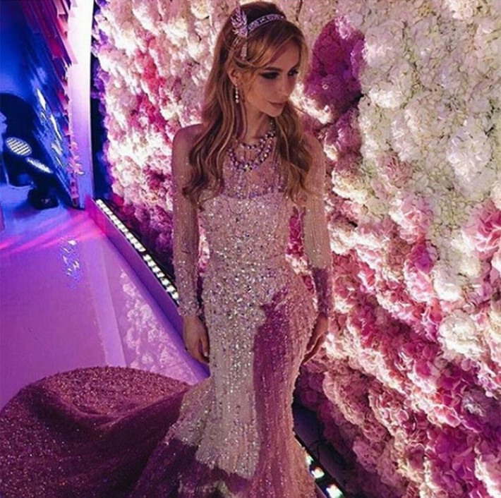 Cô dâu diện 3 bộ váy cưới khác nhau được thiết kế riêng, trong đó có một bộ váy Elie Saab trị giá 35.000 USD với trang sức trị giá 200.000 USD. Chiếc vòng Tiffany Savoy trên đầu cô dâu làm từ kim cương và ngọc trai, giống nữ diễn viên Carey Mulligan trong phim The Great Gatsby.