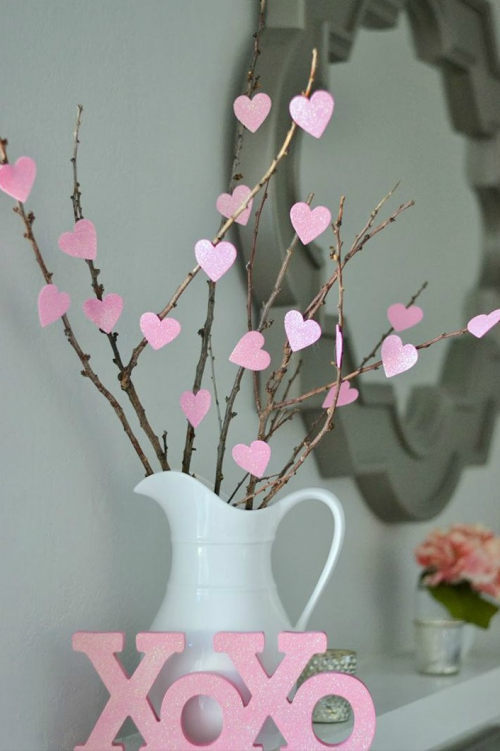 Lọ hoa này là một trong những vật trang trí dễ làm nhất. Tận dụng cành củi khô và dán hình trái tim lên là đã có một lọ hoa đậm chất Valentine, Đặt khung hình của người mình yêu mến dưới lọ hoa sẽ tăng phần hấp dẫn.