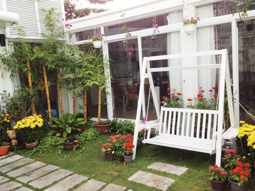 Trong sảnh của ngôi nhà còn đặt một chiếc xích đu màu trắng cạnh những khóm hoa khiến cho ta có cảm giác như lạc vào một công viên chứ không còn đơn giản là không gian sống.