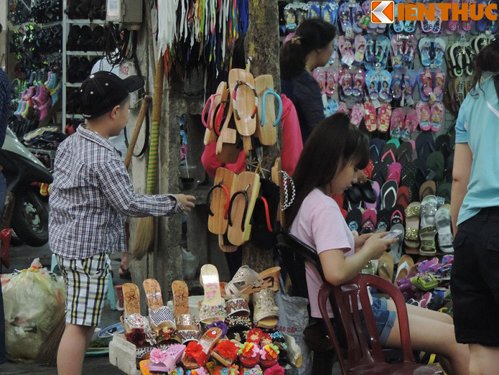 Một loạt cây xanh trên phố Lò Sũ bị người dân tận dụng, biến thành của riêng. Những cây nhỏ, thân khẳng khiu cũng không thể tránh được cảnh đóng đinh, búa. Trong ảnh là giá đỡ bán giày, dép bằng thân cây.