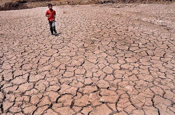 Cậu bé chạy trên ao nứt nẻ ở ngoại ô Ranchi, thủ phủ bang Jharkhand. Nắng nóng đang ảnh hưởng lớn đến sức khỏe người dân. Chính phủ Ấn Độ khuyến cáo công dân nên ở nhà, tìm nơi có bóng râm, uống nhiều nước và mặc đồ thoáng mát. Ảnh: EPA.