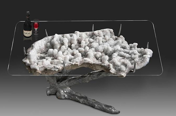 Geode table: Bên dưới mặt bàn bằng kính là một khối đá thạch anh tím được chạm trổ bằng tay, mang đến cảm giác như đang khám phá vẻ đẹp của một rặng san hô bên dưới đáy chiếc thuyền kính. Khác biệt chủ yếu ở đây là bạn có thể thưởng thức được vẻ đẹp của khối đá thạch anh tím mỗi khi ngồi vào bàn.