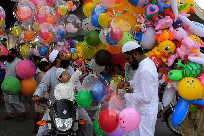 Một cậu bé chỉ tay vào bóng bay tại Karachi, Pakistan sau lễ cầu nguyện Eid al-Fitr vào tháng 5, đánh dấu sự kết thúc của tháng ăn chay linh thiêng Ramadan trong đạo Hồi. Ảnh: AFP.