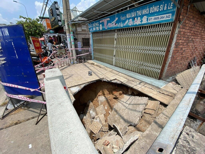 Hố tử thần "nuốt chửng" xe máy: Khoảng 9h ngày 14/4/2021, trời có mưa nhỏ, người dân trên đường Kha Vạn Cân, TP Thủ Đức bất ngờ phát hiện vỉa hè bị sụp lún tạo hố sâu khoảng 2m, đường kính khoảng 3m, khoét hàm ếch. Thềm căn nhà sát bên miệng hố cũng bị rạn nứt, nguy cơ sụt lún bất cứ lúc nào. Một xe máy đang đậu trên vỉa hè bị "nuốt chửng", vụ việc không gây thiệt hại về người nhưng dân tình chứng kiến bị một phen hú vía. (Ảnh: Giao thông)