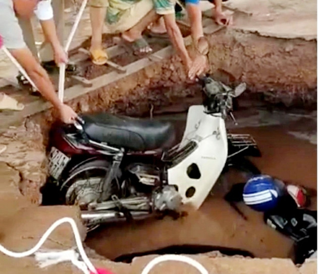 Hố tử thần xuất hiện trong trường học "nuốt chửng" nhiều xe máy: Trước đó, ngày 29/5/2020, tại Trường Tiểu học Trần Quốc Toản (xã Ya Tờ Mốt, huyện Ea Súp, tỉnh Đắk Lắk) đã xuất hiện hố tử thần khiến 2 chiếc xe máy bị rơi xuống hố sâu. Rất may, thời điểm bị sụt lún giáo viên và học sinh đã vào lớp nên không thiệt hại về người. Thời điểm hố vừa sụt chỉ là một hố nhỏ phía bên dưới nước dâng lên. Đến sáng hôm sau, hố này đã bị lở dần, lan rộng ra hơn 5m.(Ảnh: Bảo vệ pháp luật)