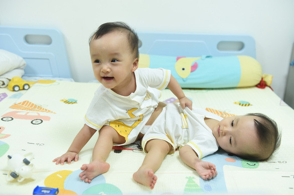 Trúc Nhi - Diệu Nhi sinh ra với hình hài dính chặt nhau vùng bụng chậu. Mọi sinh hoạt đơn giản nhất của 2 con như tắm rửa, mặc quần áo, ăn uống... cũng rất khó khăn. (Ảnh: Tuổi Trẻ)