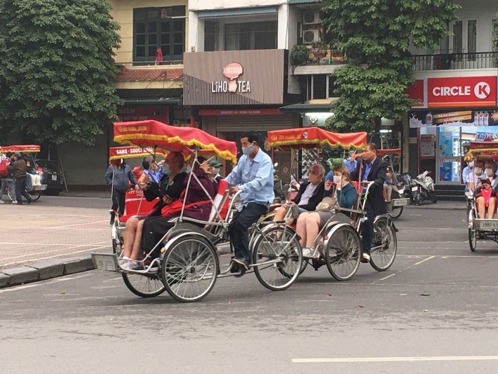 Một số hành khách chấp hành việc đeo khẩu trang khi được các bác tài xế xích lô yêu cầu khi đi dạo phố cổ.