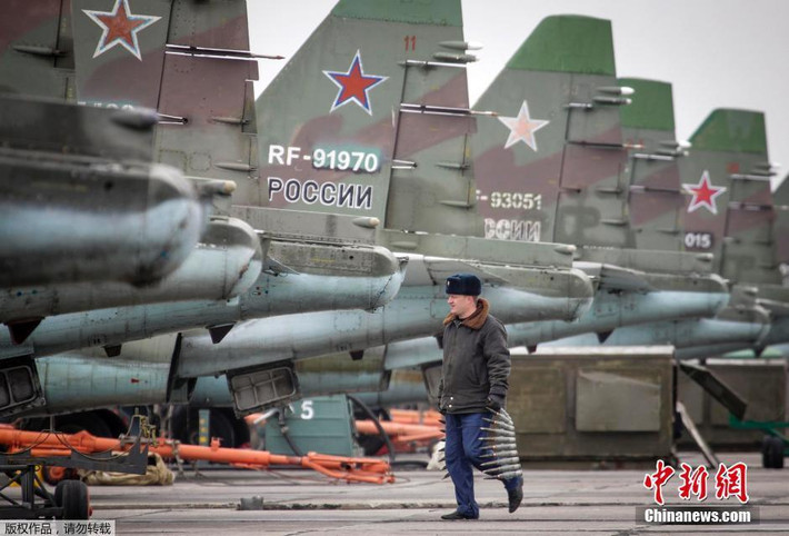 Cán bộ kĩ thuật đang đưa dây đạn pháo tới lắp cho các máy bay cường kích Su-25SM.