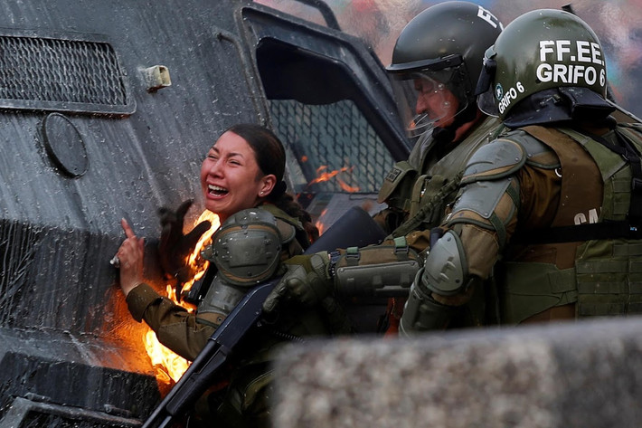 Các phóng viên Reuters tại thủ đô Santiago đã ghi lại khoảnh khắc hai nữ cảnh sát chống bạo động bị bốc cháy sau khi trúng bom xăng của người biểu tình ở Chile, gần nhà ga Baquedano hôm 4/11. Ảnh: Reuters