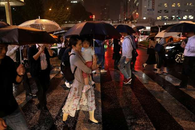 Người dân đang vội vã sơ tán tại một con phố ở Tokyo hôm 11/10. Được biết, khoảng hơn 6 triệu người đã được yêu cầu di dời khỏi chỗ ở. (Ảnh: Reuters)