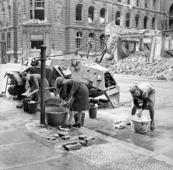 Người phụ nữ Đức đang giặt quần áo bằng nước lạnh trên một con phố Berlin năm 1945.