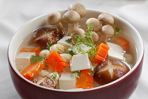 Canh nấm hạt sen là món chay dễ làm lại rất bổ dưỡng. Nguyên liệu món canh cũng dễ tìm. Hạt sen và nấm rửa sạch, cà rốt tỉa hoa, cắt lát. Cho hạt sen và cà rốt vào nấu trước với chút dầu ăn cho mềm. Tiếp tục cho nấm vào nấu chín, nêm gia vị vừa miệng. Cuối cùng cho hành ngò vào. Ảnh: amthucchay