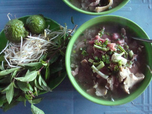 Cháo bò Tri Tôn có mùi vị quyến rũ của lòng bò và hương thơm đặc trưng của trái trúc. Muốn có được bát cháo ngon trước hết phải chọn được thịt bò bản địa (bò nuôi tại vùng Bảy Núi). Bát cháo là sự tổng hợp của gạo, thịt, gân, đồ lòng và gia vị đi kèm là hành, ngò, gừng xắt nhỏ và các loại rau thơm như mò om, ngò gai. Ảnh: hotel84