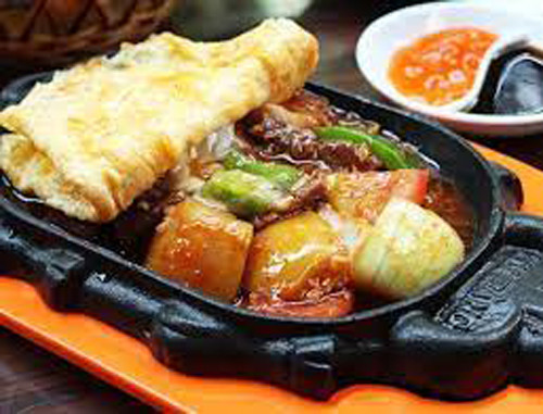 Bò trùm mền. Bò trùm mền có nguyên liệu chính là thịt bò, pate và trứng tráng. Sự hài hòa giữa các nguyên liệu mang tới món ăn hương vị hấp dẫn, thịt bò đậm đà và mềm mại, không dai, thơm nhẹ mùi tỏi, nước tương và ngũ vị hương.