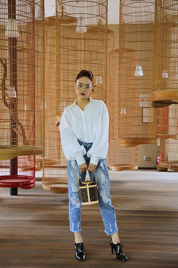 Sơ mi tay bồng hot trend của mùa mốt mới được Minh Hằng chọn lựa để kết hợp cùng quần jean rách. Cô tạo thêm điểm nhấn cho tổng thể bằng mẫu túi xách tay mới ra lò của thương hiệu Louis Vuitton.