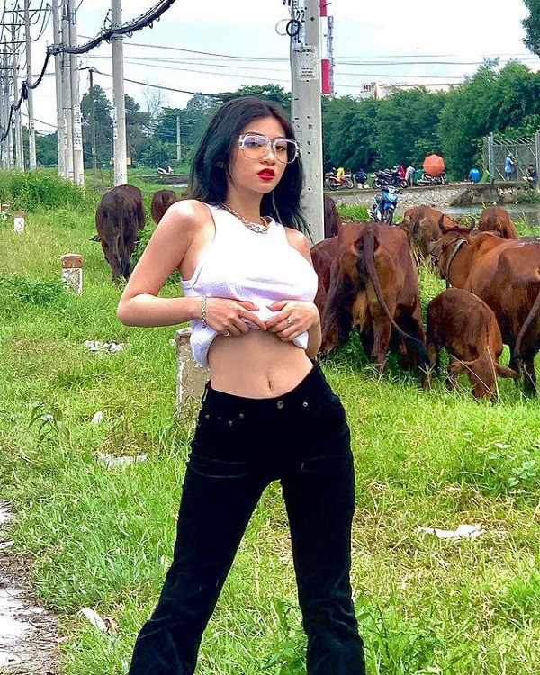 Diện bộ đồ kín đáo, hotgirl 10X dùng tay vén áo để khoe eo thon không ngấn mỡ.