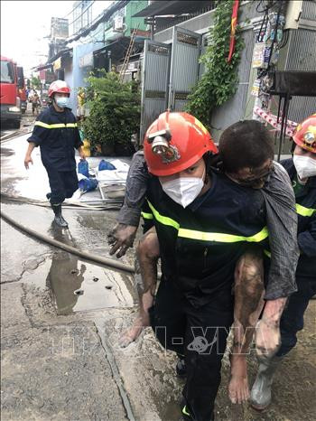 Đội Cảnh sát PCCC&CHCN, Công an quận Bình Tân giải cứu nạn nhân trong vụ cháy lớn tại nhà dân ở địa chỉ số 34, đường số 14A, phường Bình Hưng Hòa A, quận Bình Tân, TP HCM vào sáng 5/9/2021. (Ảnh: TTXVN)