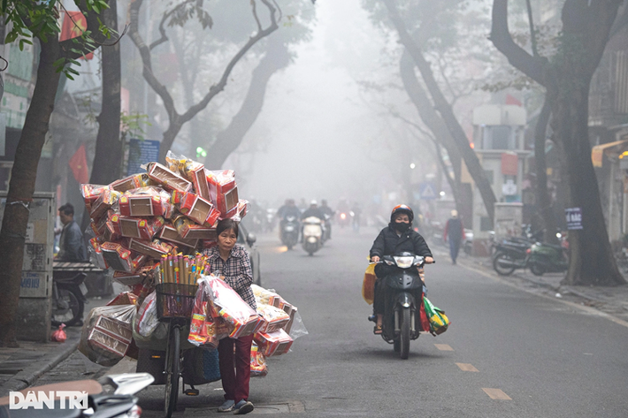 Trong khu vực phố cổ, người dân lưu thông trên phố Hàng Chiếu (quận Hoàn Kiếm) cũng bị ảnh hưởng bởi sương mù làm hạn chế tầm nhìn (Ảnh: Mạnh Quân).