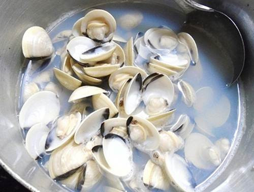 Bước 2: Ngao rửa sạch, cho vào nồi, đổ ngập nước rồi thêm vài hạt muối vào luộc. Khi ngao mở miệng thì bạn tắt bếp, vớt ra tách lấy phần thịt, ướp cùng mắm, mỳ chính, bột canh, 1/3 chỗ hành khô cho ngấm gia vị. Nước luộc ngao đổ ra bát cho lắng cặn.