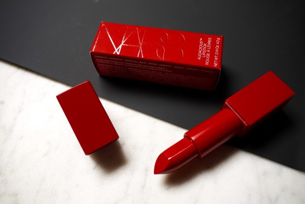 Son Nars vỏ đỏ. Cây son ấn tượng này có mã màu Rita, thuộc dòng son Audacious trứ danh của thương hiệu Nars. Cả thân và vỏ son đều được phủ lên một màu đỏ đồng nhất từ trong ra ngoài, chỉ nhìn thôi cũng đã đủ khiến chị em phụ nữ “điên đảo” vì thiết kế bắt mắt. Chất son satin mềm mượt, có độ bóng nhẹ nhàng, làm mềm môi vừa đủ nhưng hiệu ứng lại không bị quá bóng mà vẫn đạt được độ lì nhất định.