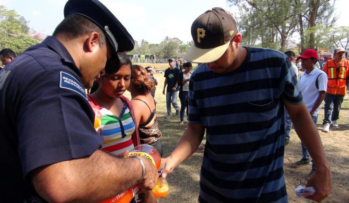 Hình ảnh một cảnh sát Mexico đổ nước giải khát cho một người nhập cư tại Matias Romero, Oaxaca, Mexico. Ảnh: Reuters.