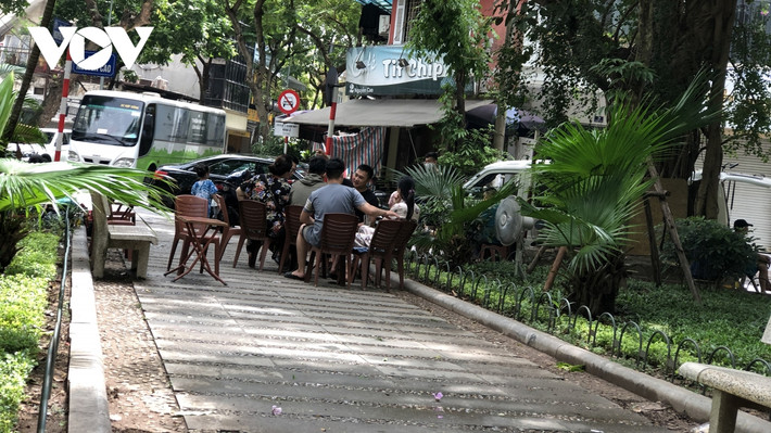 Vi phạm diễn ra ở mọi thời điểm trong ngày, không chỉ vỉa hè bị lấn chiếm, vườn hoa cũng bị các quán cafe "mượn" để bố trí cho khách ngồi.