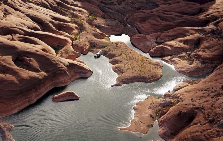 Góc nhìn khác của hồ Powell, nằm trên dòng sông Colorado, cho thấy một nhà thuyền tạm trú ven bờ tại vùng nước nông trong một hẻm núi ở hồ Powell gần thị trấn Page, Arizona, Mỹ.