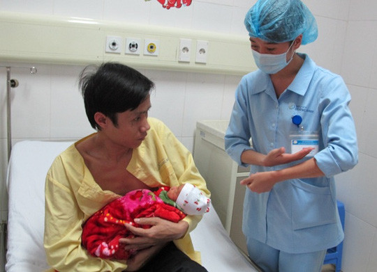 Khá lúng túng khi chăm sóc cậu con trai sinh non mới được 31 tuần tuổi bằng phương pháp "da kề da" nên anh Thiều Văn Thương được điều dưỡng hướng dẫn tận tình.
