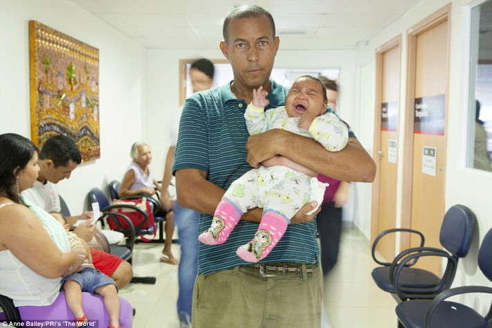 Paulo Rogerio Cavalcanti Araújo, 47 tuổi bế con gái 4 tháng tuổi Eduarda Vitória trong vòng tay.