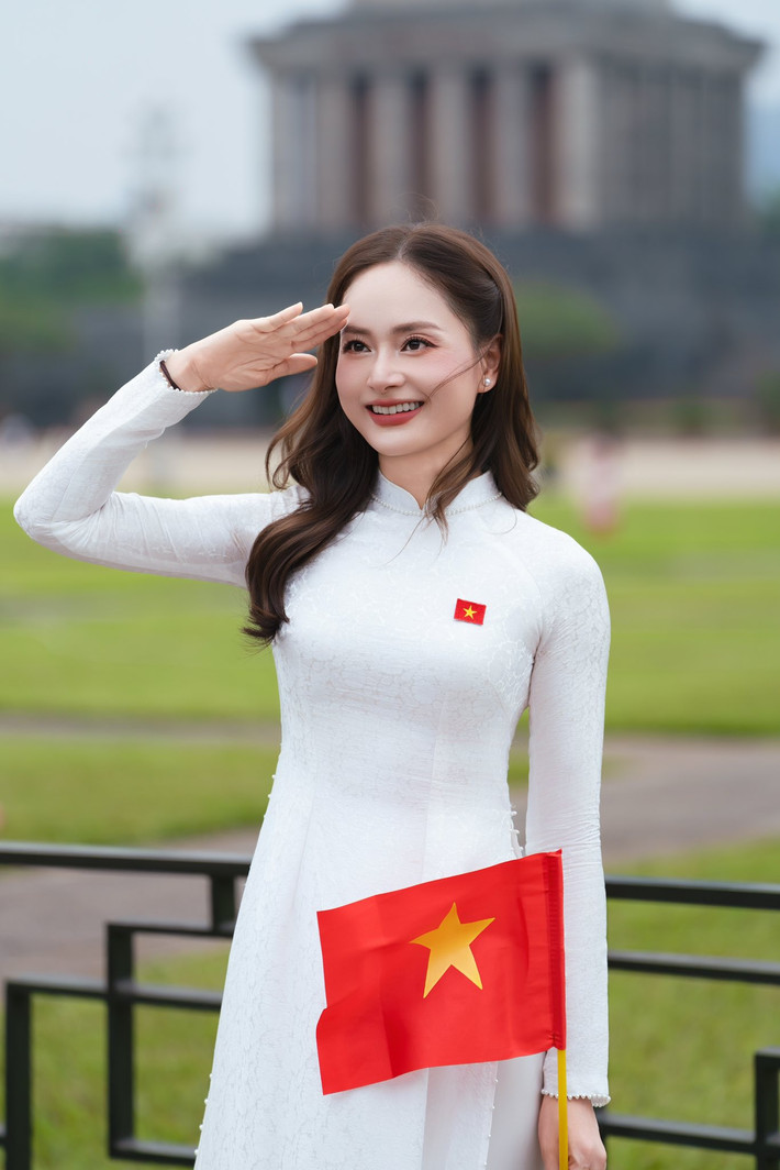 Lan Phương mặc áo dài trắng, trên ngực gắn cờ đỏ sao vàng. Ảnh: FB Lan Phương