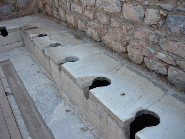 Đây là những chiếc bồn cầu ở thành phố cổ Ephesus, Thổ Nhĩ Kỳ 2000 năm trước. Nước từ những nhà vệ sinh này được xả trực tiếp xuống dòng sông ngay phía dưới, rồi được tập trung lại để xử lý.