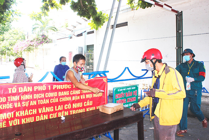 Việc giao nhận hàng hóa của người dân được thực hiện tại chốt bảo vệ “vùng xanh”. (Ảnh: Vùng xanh 250 hộ/1.150 nhân khẩu phường Phước Long ,TP. Nha Trang)