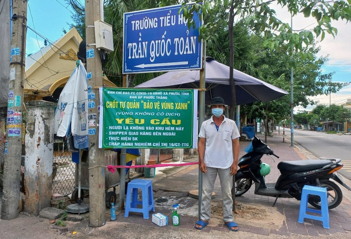 Thành viên tổ COVID-19 cộng đồng và người dân trong khu dân cư tự nguyện làm nhiệm vụ túc trực tại chốt. (Ảnh: Báo Nhân dân)