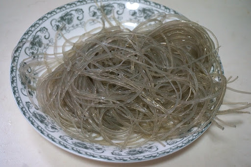 Ta cho 1 thìa muối ăn, đảo đều rồi để riêng ra ướp trong 10 phút, dùng tay vắt bớt nước trong bí đã ướp. Trong lúc đó tranh thủ ngâm miến.