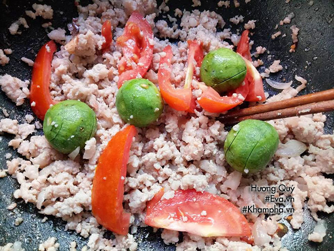 Trong lúc đảσ nhanh tay cho 1 thìa hạt nêm và cà chua. Đảσ cho đến khi cà chua chín nhuyễn ra , tan ra làm nước màu đỏ. Lúc này vặn nhỏ lửa, cho hỗn hợp sôi lăn tăn, vị chua từ cà chua và sấu tan ra và thấm vào thịt. Ảnh: eva.vn.