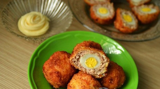 Lăn viên thịt đó qua lớp bột mì (hoặc bột chiên giòn), rồi lăn qua bát trứng gà, tiếp đến là lăn qua bột chiên xù. Sau đó đem chiên trong chảo dầu, chín vàng là được. Khi ăn, có thể chấm với sốt mayonnaise, tương ớt. Ảnh: menaunuong.WordPress.com.
